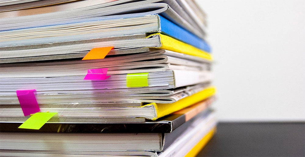 Close-up van een stapel administratieve papieren met gekleurde bladwijzers