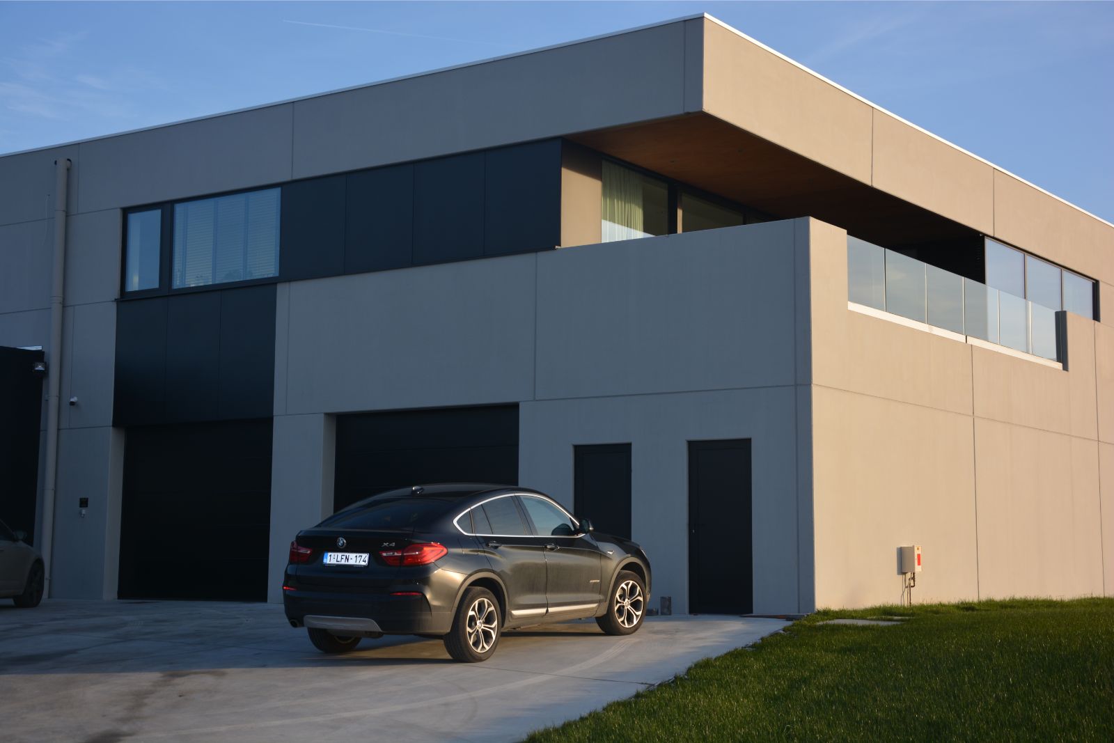 Nieuwbouw kantoor en woning, in grijs beton, realisatie van Plan Architectenbureau Brugge