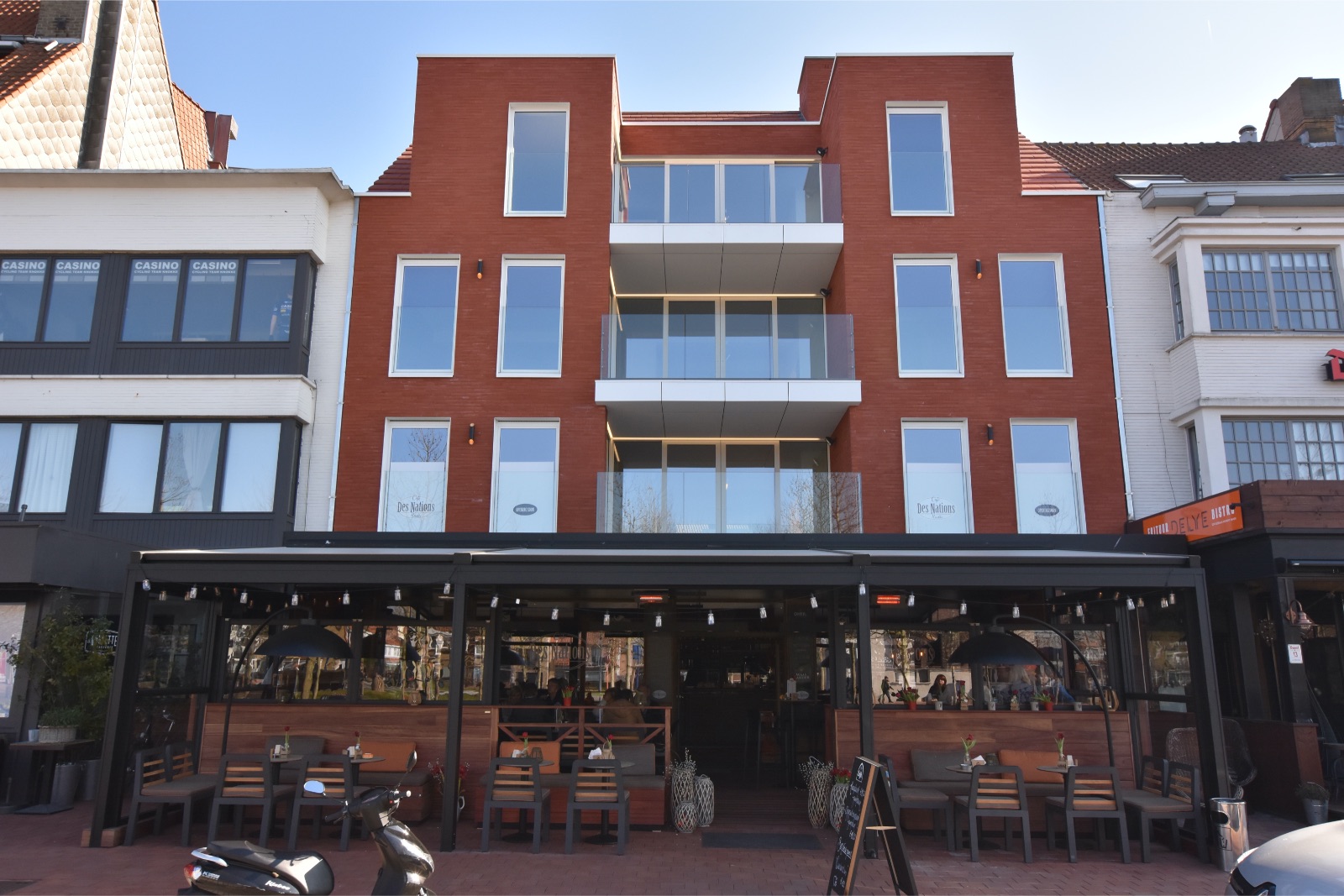 Gerenoveerd appartementsblok in rode bakstenen en grote glaspartijen, realisatie van Plan Architectenbureau Brugge