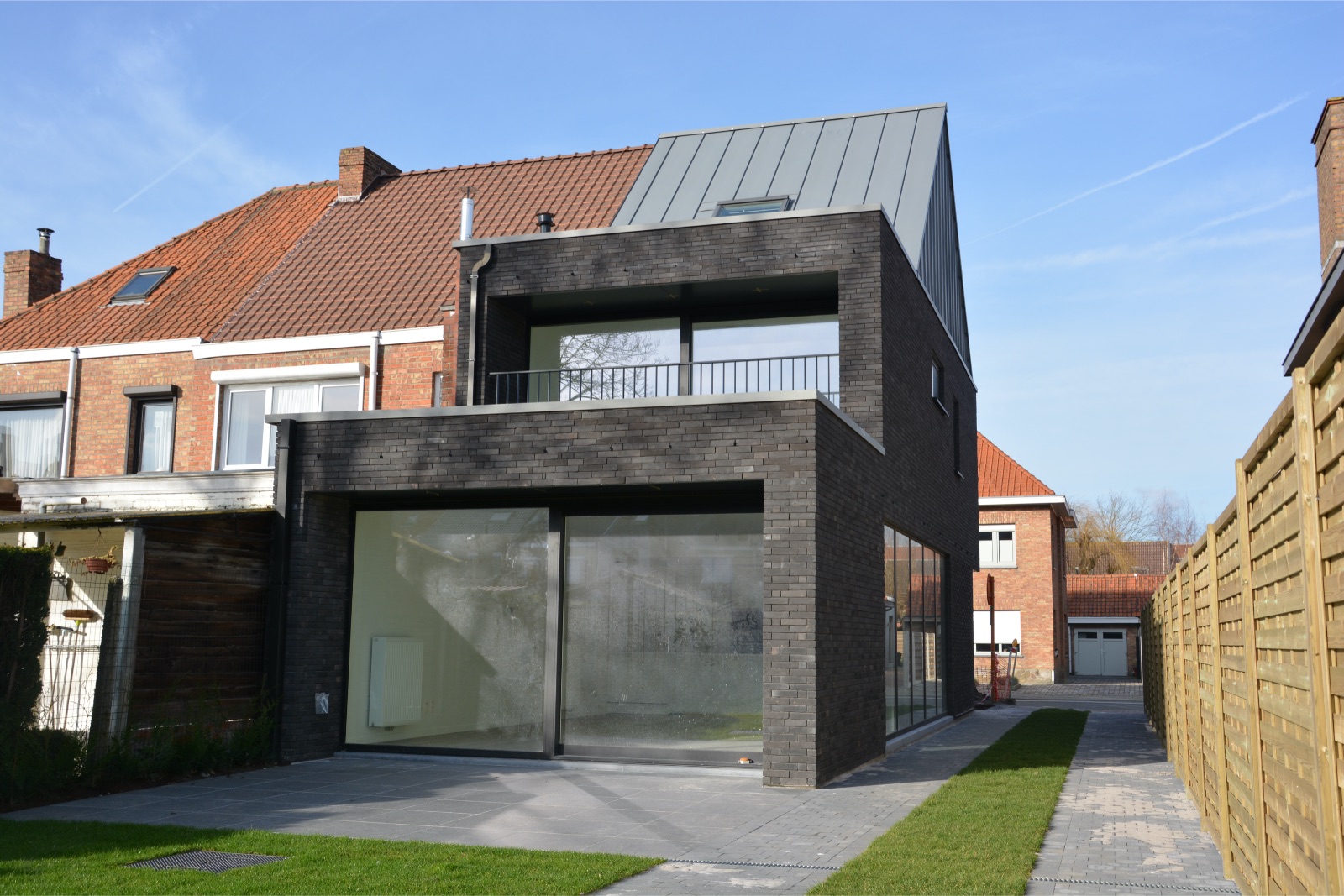 Achteraanzicht van een verbouwing en nieuwbouwwoning, realisatie van Plan Architectenbureau Brugge