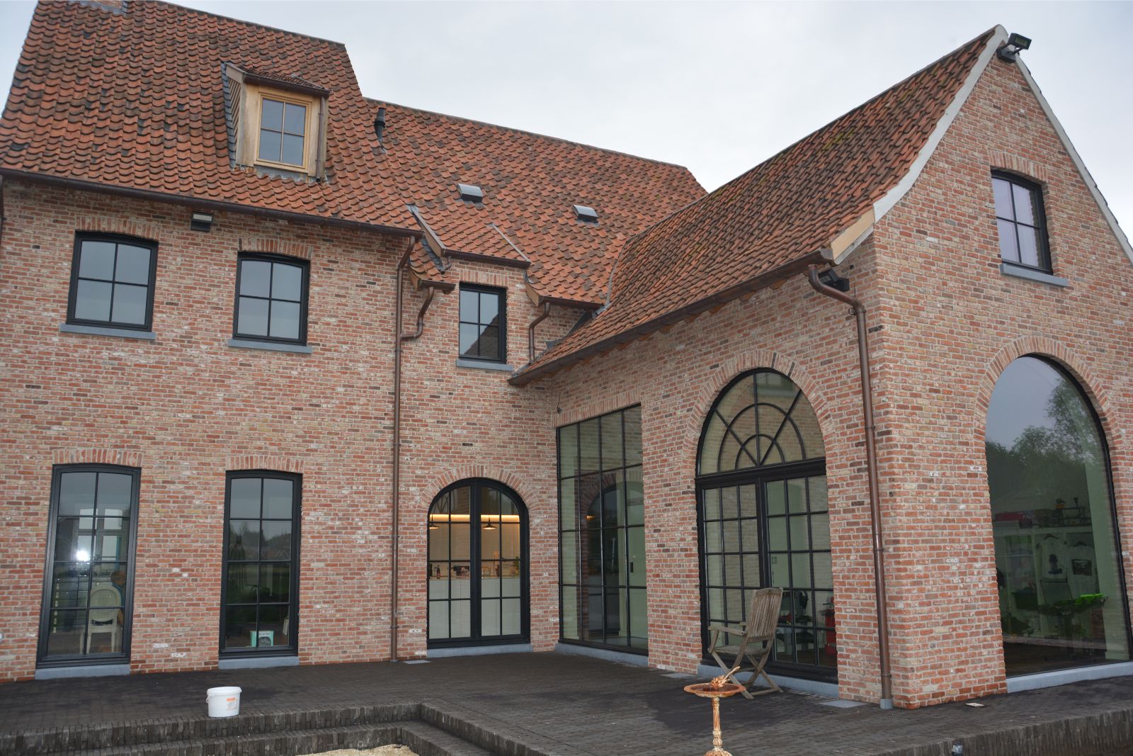 Nieuwbouwwoning in landelijke stijl, huis uit baksteen met grote glaspartijen, realisatie van Plan Architectenbureau Brugge
