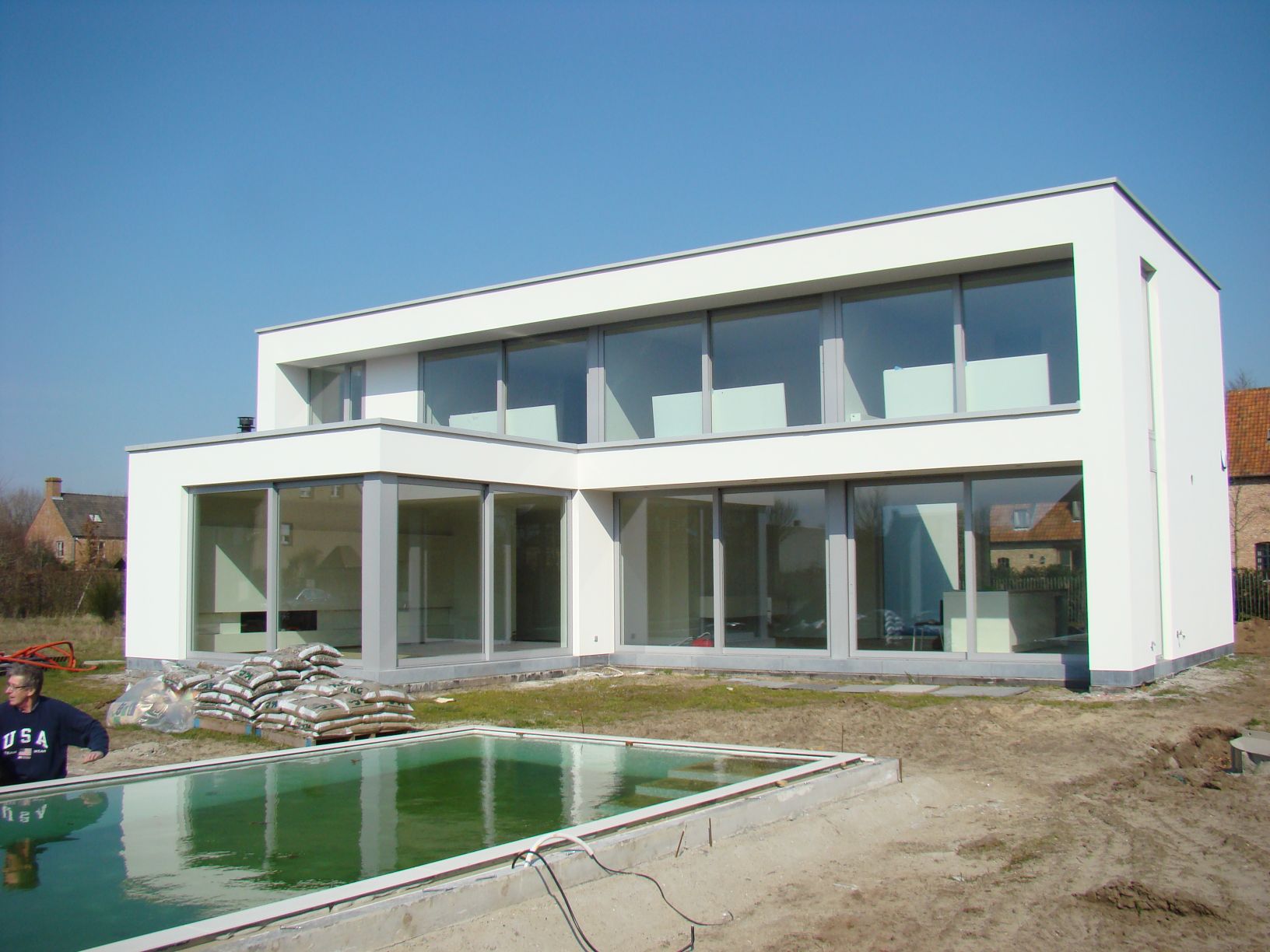 Achteraanzicht van een moderne witte nieuwbouwwoning, realisatie van Plan Architectenbureau Brugge